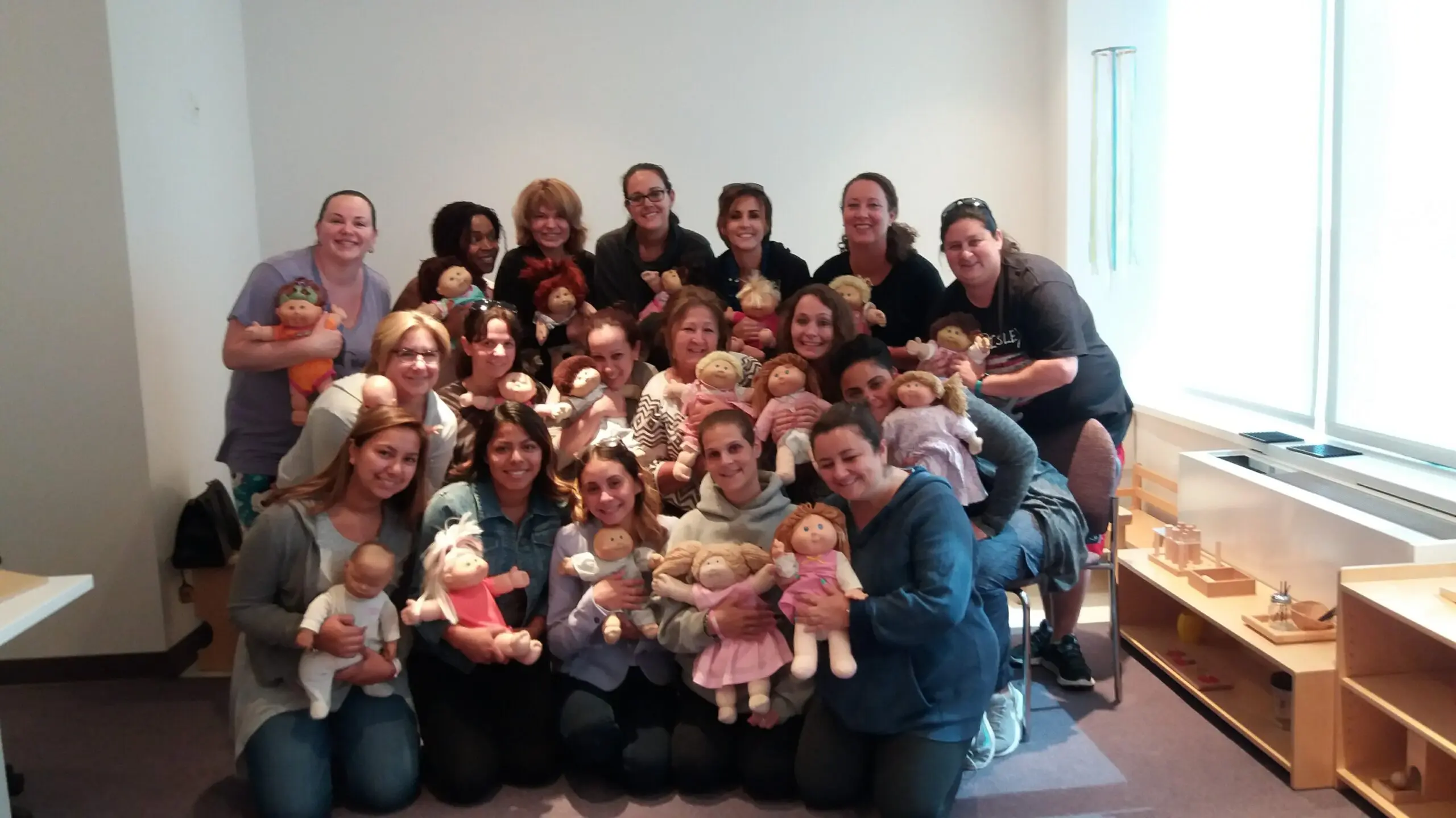Group photo with people holding dolls.