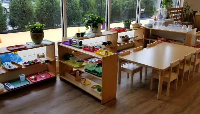 Classroom with shelves and small tables.