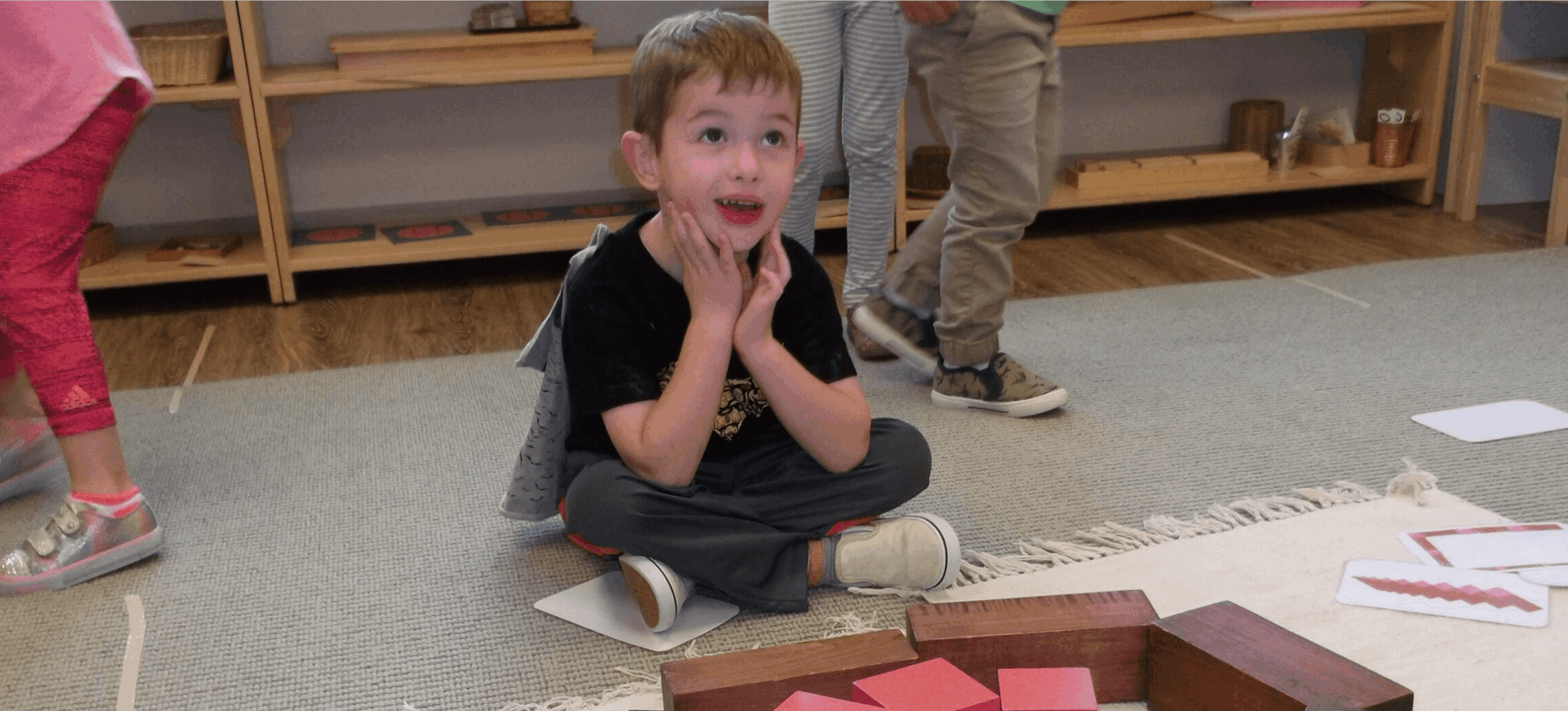 Child sitting on floor, looking surprised.