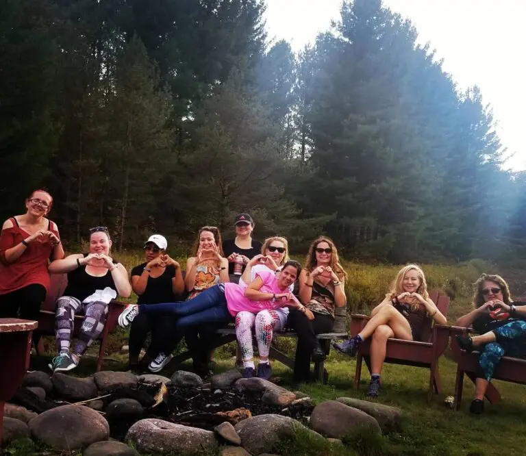 Group of women posing outdoors near trees.