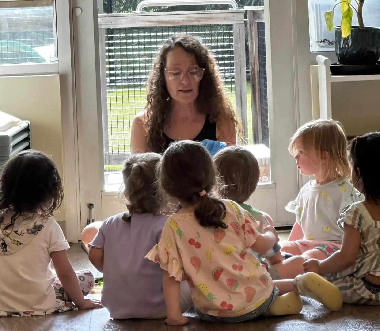 Woman reading story to preschool children