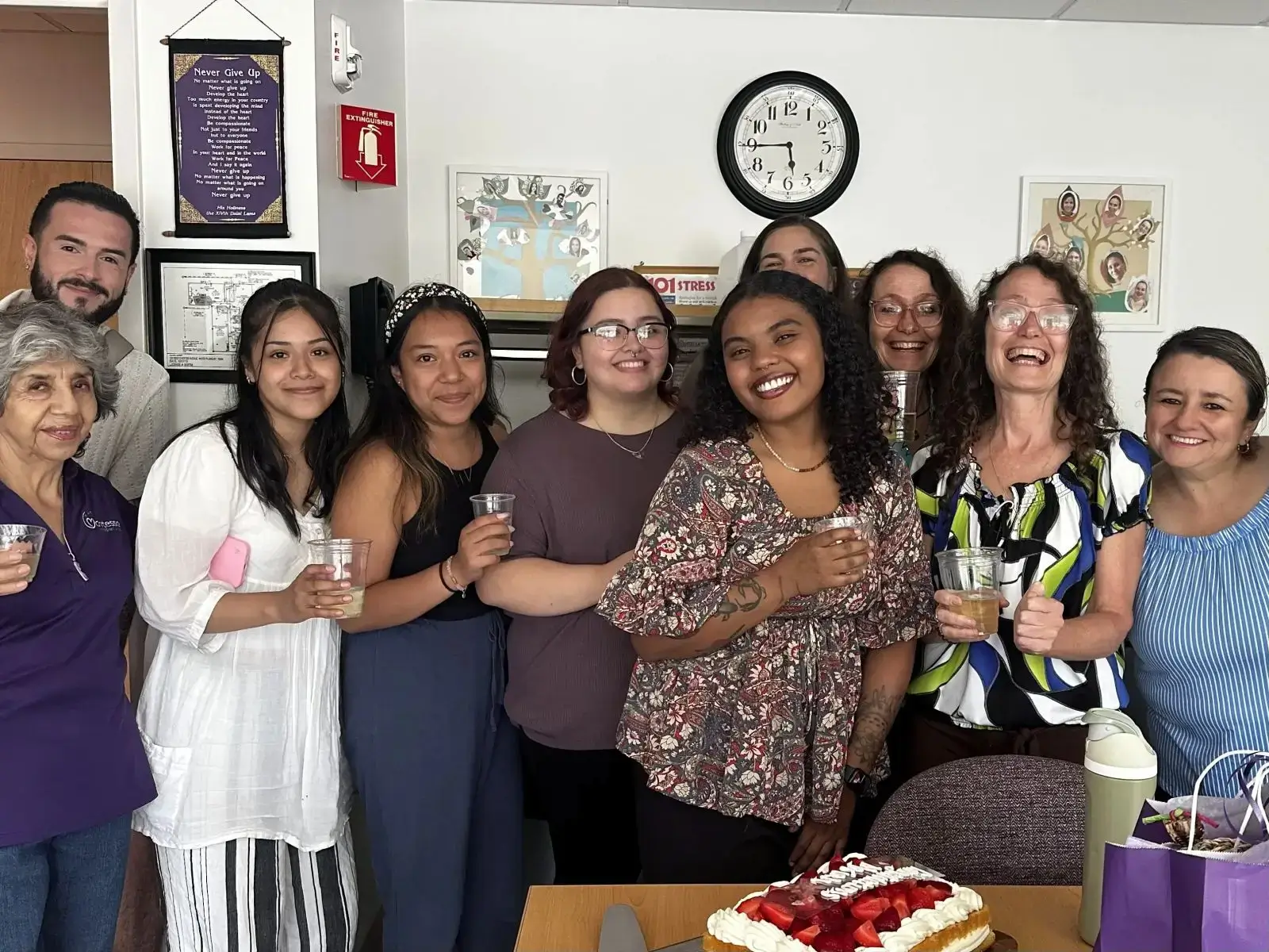 Smiling coworkers celebrating with cake and drinks