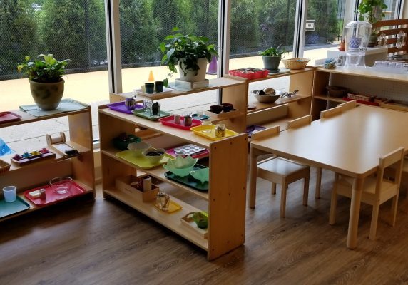 Classroom with shelves and small tables.