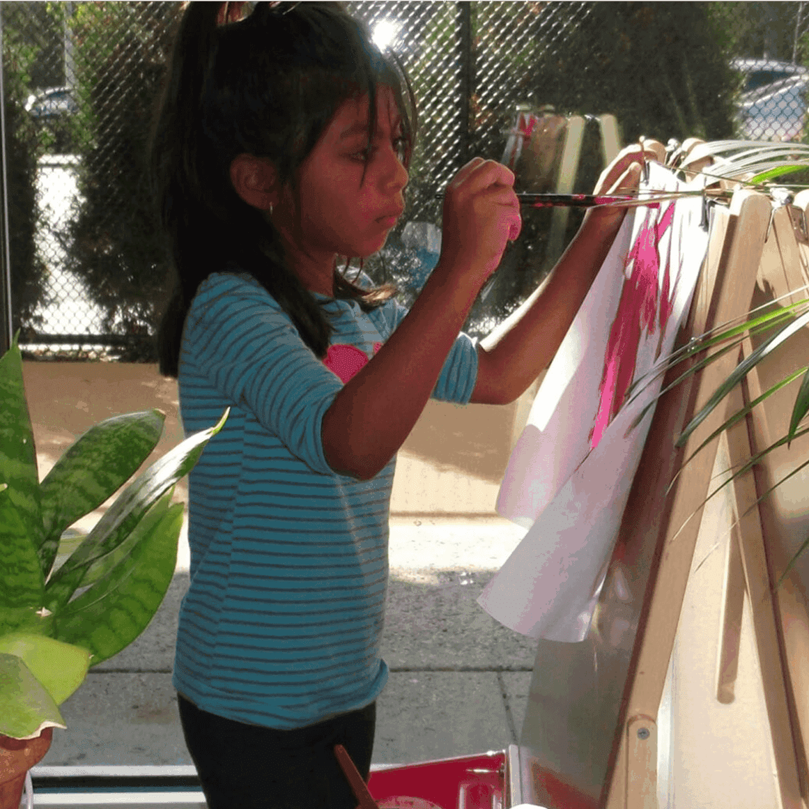 Child painting at an indoor easel station.