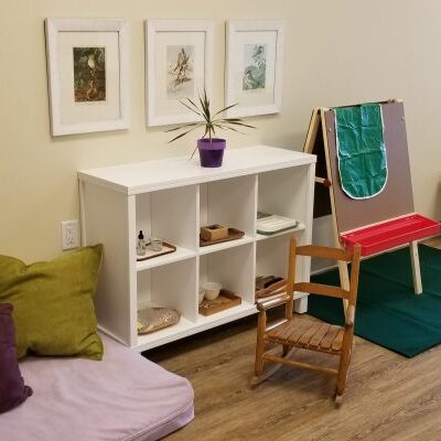 Montessori classroom with shelves and easel.